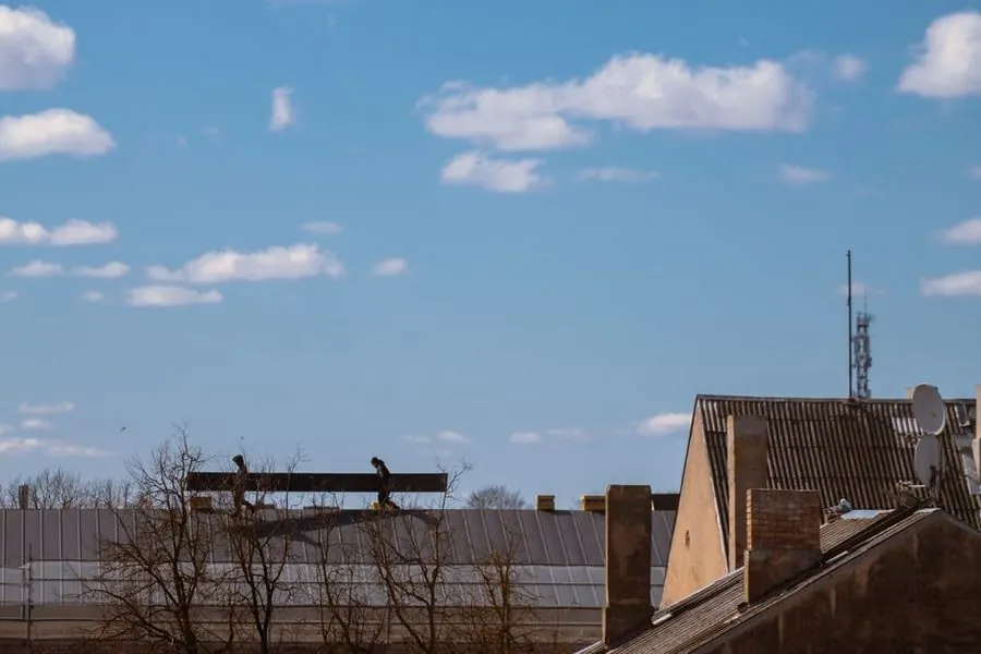 A roofer surveying a roof to price up a re-roofing job