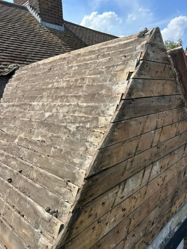 Before: an old roof stripped back to the bare timber boarding in Sussex